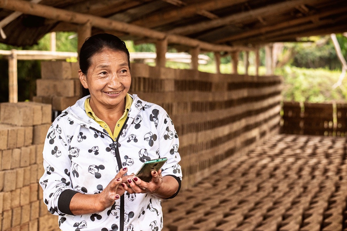 G2P recipient in Colombia holds her mobile phone
