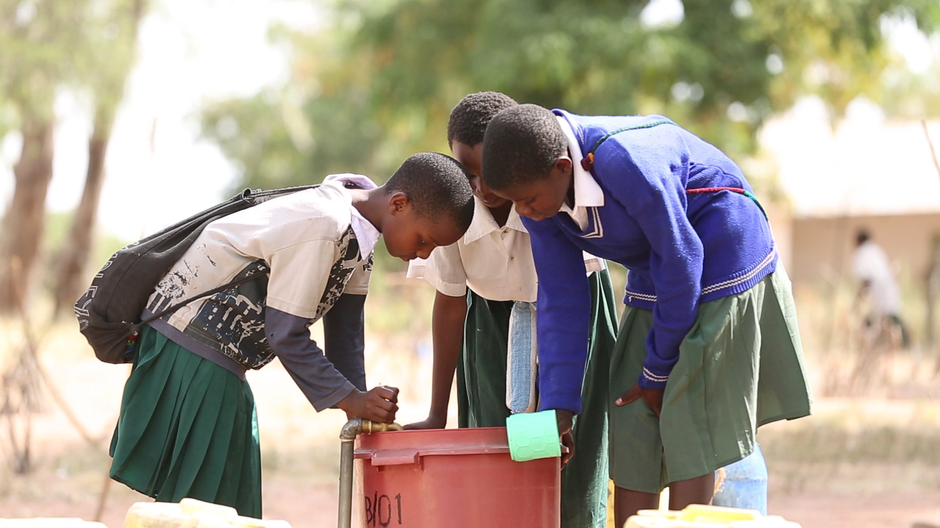 Residents of a village in Tanzania draw water.
