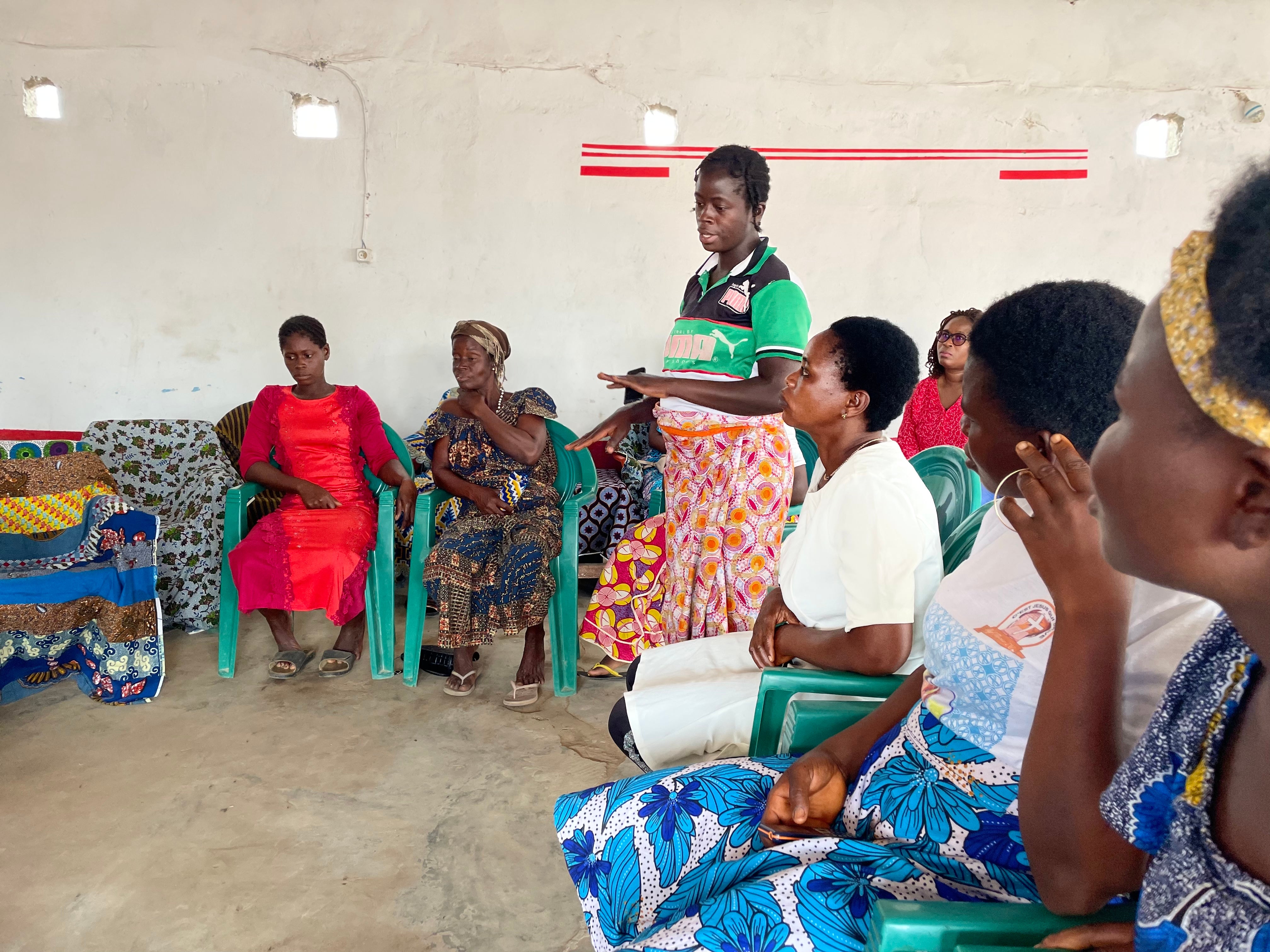 Women meet in a room with plastic chairs