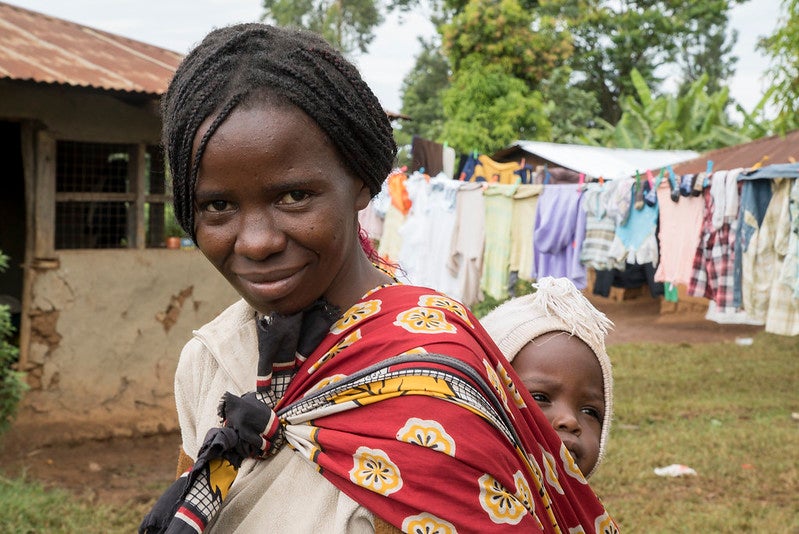A woman returns home from shopping outside of Kisumu, Kenya.
