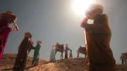 Women in rural Sindh, Pakistan, walk uphill with baskets on their heads