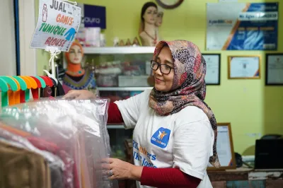 A woman inspects clothes in her shop