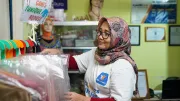 A woman inspects clothes in her shop