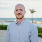 headshot of man with beach as backdrop