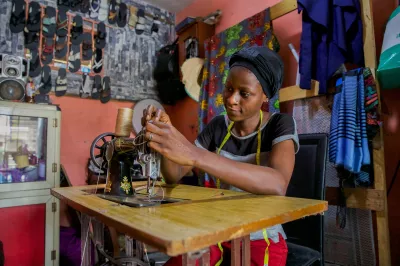 a woman setting up her sewing machine in her shop in Nigeria