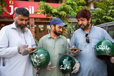 A group of riders from Bykea, a Pakistani ride hailing and parcel delivery company, use their smartphones to look for rides early in the morning outside the company’s headquarters in Islamabad.