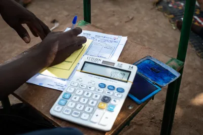 An employee for an MFI in Mali does paperwork.