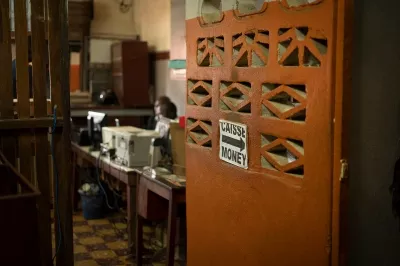 A sign on a door shows the direction to a shop at the Abobo market in Abidjan, Cote D'Ivoire