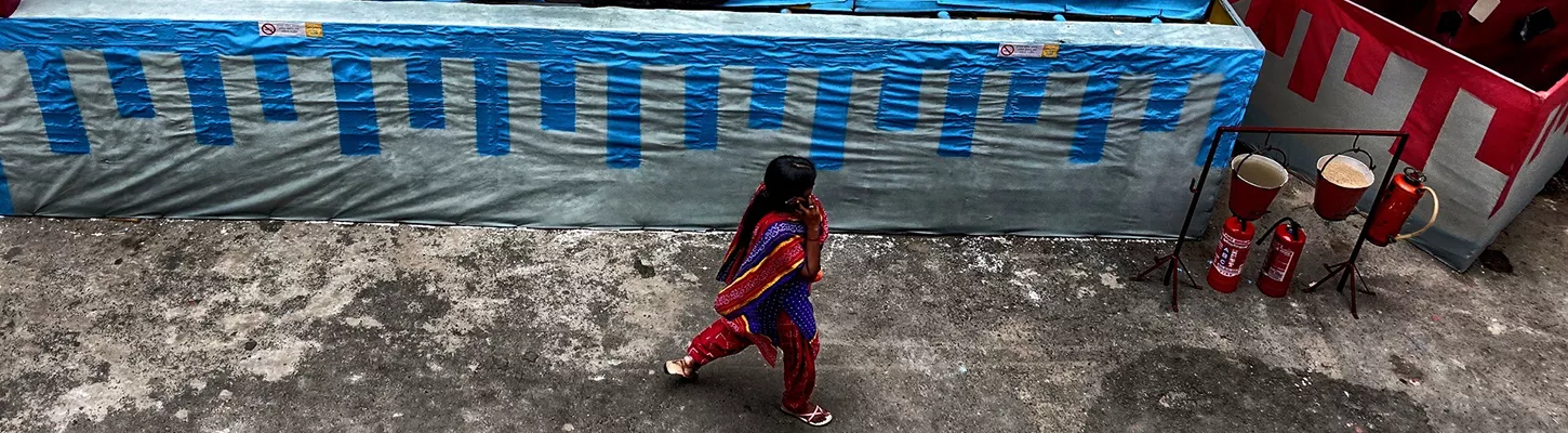 a pedestrian viewing street art depicting a desk worker