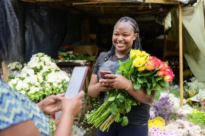 two african women about to make a contactless payment for flowers