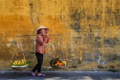 Vietnamese woman selling tropical fruits, old town in Hoi An city, Vietnam