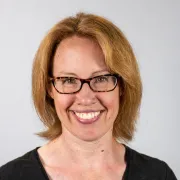 headshot of woman with glasses against white background