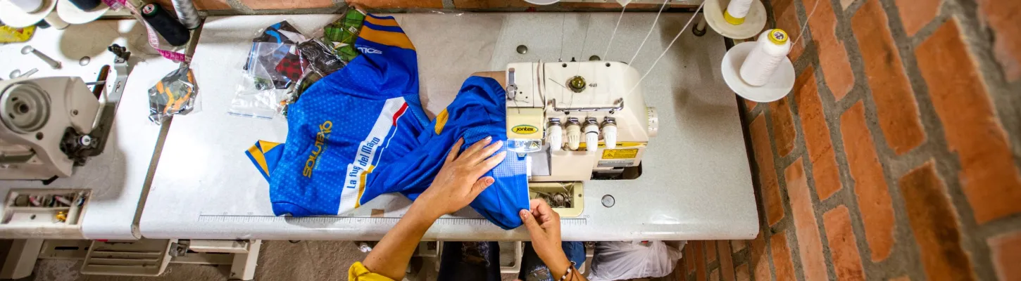 woman sitting at desk sewing 
