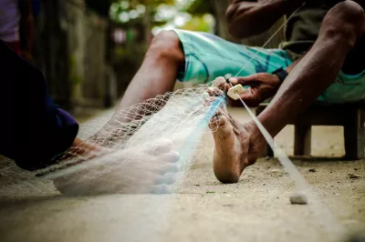 a fisherman is fixing his net