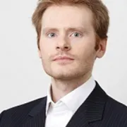 headshot of man in dark suit against white background