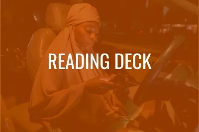 a woman sitting in the driver seat of a parked car looking at her phone