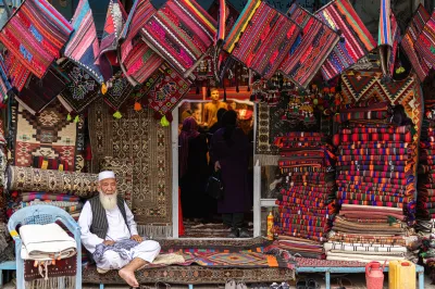A man sits outside a rug shop