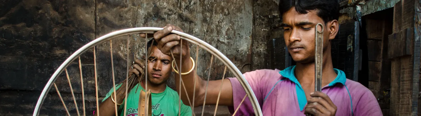 two men fixing van wheels in a workshop